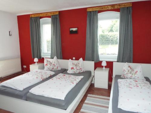 1 dormitorio con 2 camas y paredes rojas en Ferienwohnung Lindemann, en Weißig