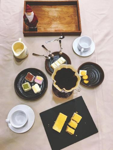 a table topped with plates of cheese and a pie at Dan’s Sea Guest House Hangzhou in Hangzhou