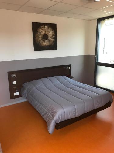 - un grand lit dans une chambre avec publicité dans l'établissement Le Patio, à Saint-Varent