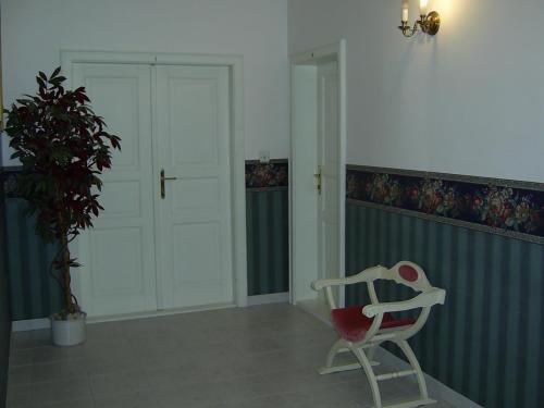 a rocking chair in a room with a plant at Pension Šejko in Horní Planá