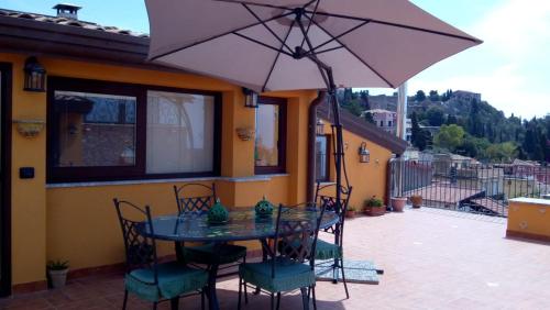 a table and chairs with an umbrella on a patio at Attico Sole Luna in Taormina