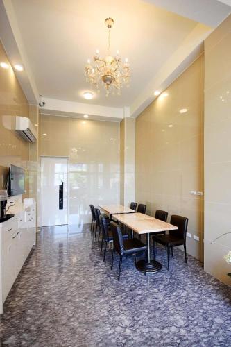 a dining room with a table and chairs and a chandelier at Dong-Qing Swiss Homestay in Chaozhou