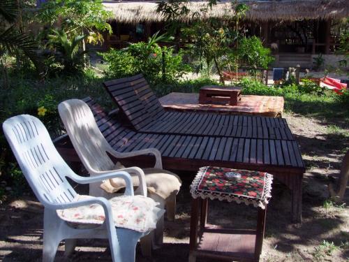 a group of chairs and a table and a bench at Baan Suan Kayoo 2 Buffalo Bay Aow Khao Kwai in Ko Phayam