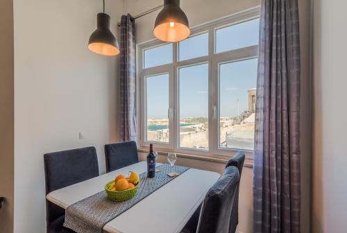 une salle à manger avec une table et une grande fenêtre dans l'établissement Valletta Harbour View, à La Valette