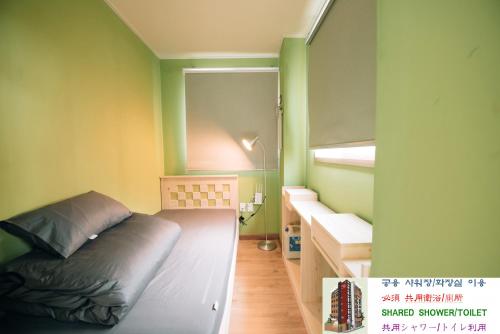 a small room with a bed and a window at Daegu Midtown Hostel in Daegu