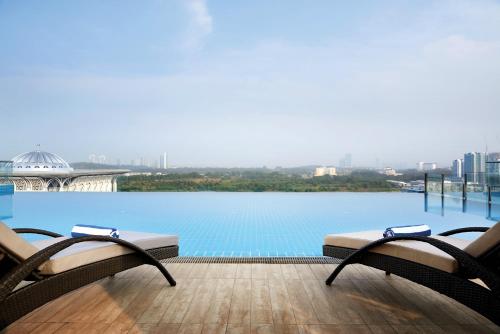 a view of a swimming pool with two chairs at Dorsett Putrajaya in Putrajaya