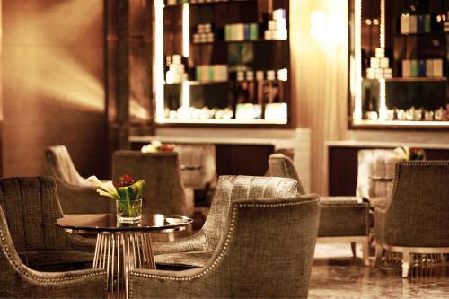 a room with chairs and a table with a vase of flowers at Dorsett Putrajaya in Putrajaya