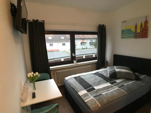 1 dormitorio con cama, mesa y ventana en Living @ Klassvilla Weserwehr No. 1, en Bremen