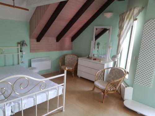a bedroom with a bed and chairs and a mirror at Pr'Simi in Golnik
