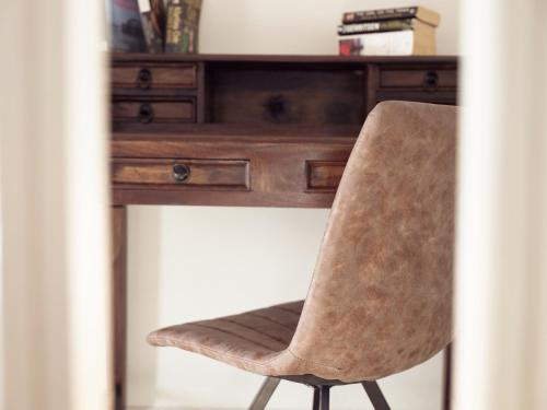 a wooden desk with a chair in front of it at Three Graces Holiday Houses Complex in Laganas