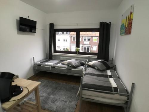 Kleines Zimmer mit einem Bett und einem Fenster in der Unterkunft Living @ Klassvilla Weserwehr No. 4 in Bremen