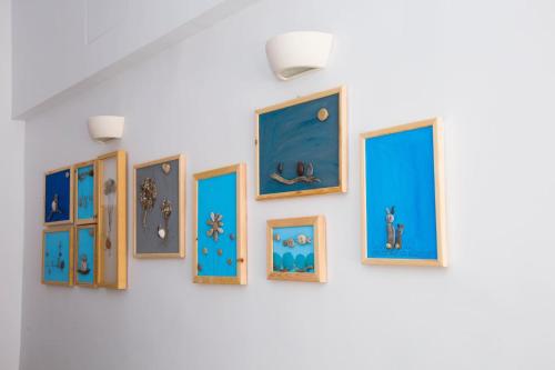 a group of framed paintings on a wall at Elenis Philoxenia in Ixia