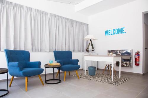 a room with two blue chairs and a white table at Elenis Philoxenia in Ixia