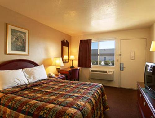 ein Hotelzimmer mit einem Bett und einem Fenster in der Unterkunft Park Avenue Inn & Suites in Victorville