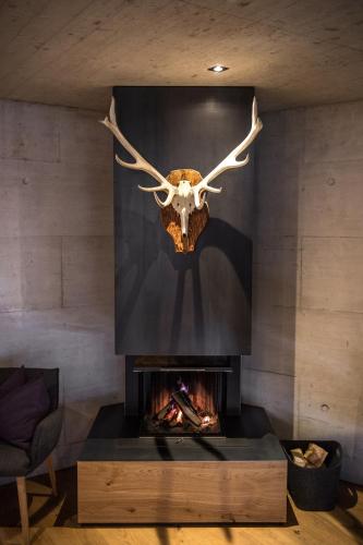 a living room with a fireplace with a skull above it at Apart6580 in Sankt Anton am Arlberg