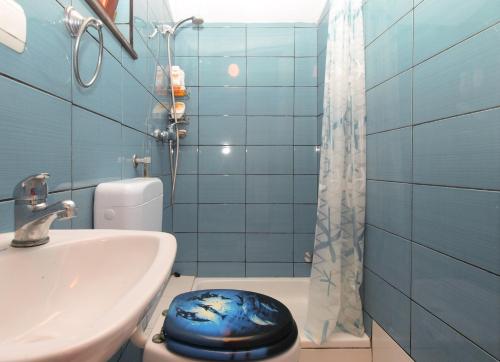 a blue bathroom with a toilet and a sink at Apartments Milan 1665 in Peroj
