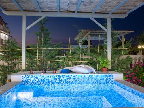 a swimming pool in the middle of a house at Three Graces Holiday Houses Complex in Laganas