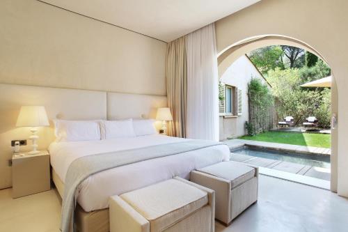 a bedroom with a bed and a large window at MUSE Saint Tropez - Small Luxury Hotels of the World in Saint-Tropez