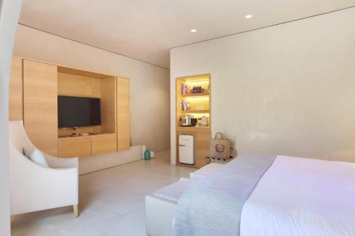 a bedroom with a bed and a flat screen tv at MUSE Saint Tropez - Small Luxury Hotels of the World in Saint-Tropez