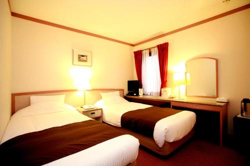 ein Hotelzimmer mit 2 Betten und einem Spiegel in der Unterkunft Arrow Hotel in ShinsaiBashi 朝食無料サービス中 in Osaka