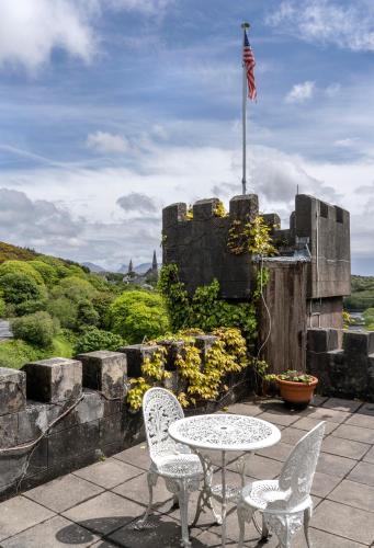 a patio with a table and two chairs and an american flag at Abbeyglen Castle Hotel in Clifden
