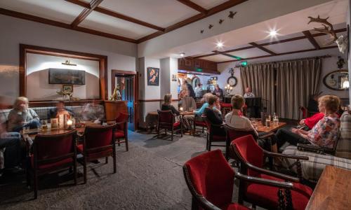 a group of people sitting at tables in a restaurant at Abbeyglen Castle Hotel in Clifden