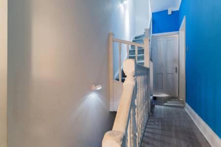 een kamer met een wieg en een blauwe muur bij Studio flat 15 min from Greenwich ( en-suite) in Plumstead