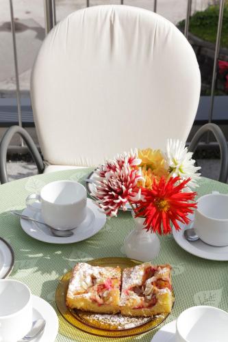 a table with a plate of food and flowers on it at Pension Waldesruh in Tarrenz