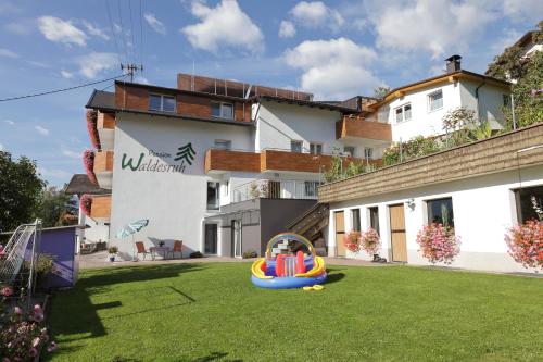 a backyard with a play equipment in the grass at Pension Waldesruh in Tarrenz