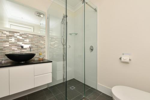 La salle de bains est pourvue d'une douche en verre et d'un lavabo. dans l'établissement Marbles on Lovedale, à Lovedale
