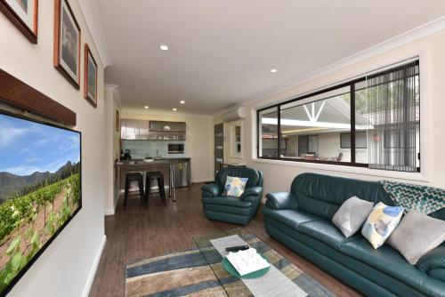a living room with a couch and a large window at Marbles on Lovedale in Lovedale
