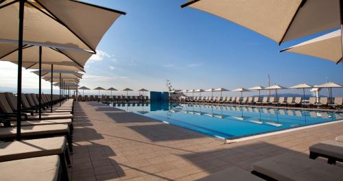 una piscina con sombrillas y sillas y una piscina en Hotel Admiral - Liburnia en Opatija