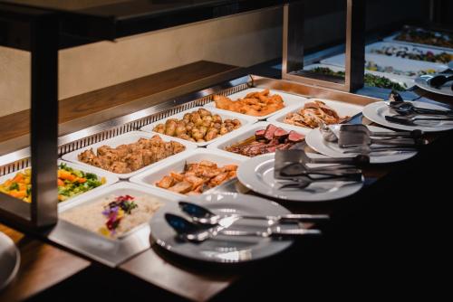 a buffet line with plates of food on a table at Village Resort Hanuliak Apartmany in Belá