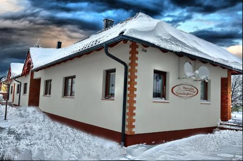 a house with snow on the roof in the snow at Hanság Vendégház in Kapuvár