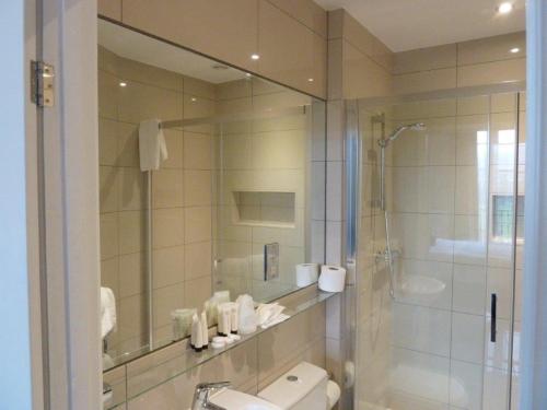 a bathroom with a shower and a toilet and a sink at Edgar Townhouse in Bath