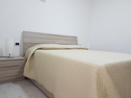 ein Schlafzimmer mit einem Bett und einem Nachttisch mit einer Tagesdecke in der Unterkunft il Gelsomino in Formia