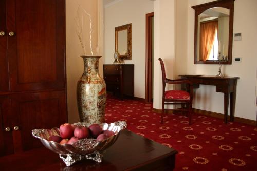 a room with a table and a vase of flowers at Grand Hotel Palace in Marsala