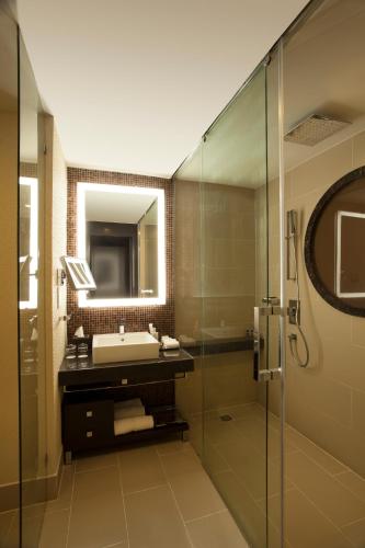 a bathroom with a sink and a glass shower at The Oterra in Bengaluru