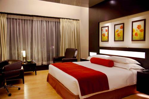 a bedroom with a large bed with a red blanket at The Oterra in Bengaluru