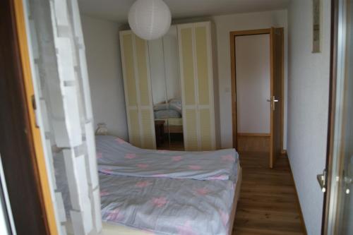 a small bedroom with a bed and a hallway at Résidence Les Mandarins D in Crans-Montana