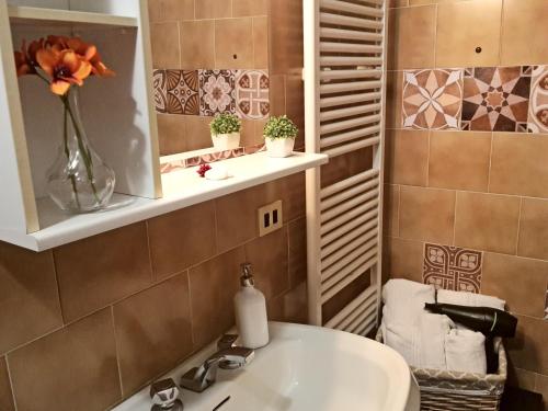 a bathroom with a sink and a vase with flowers at The Best View San Gimignano Apartments in San Gimignano