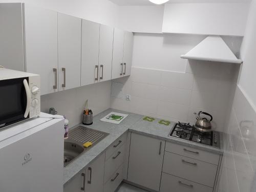 a white kitchen with a sink and a stove top oven at Mixbud in Biała Podlaska