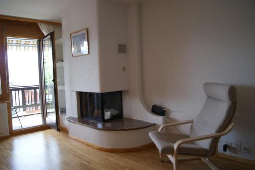a living room with a chair and a fireplace at Résidence Les Mandarins D in Crans-Montana
