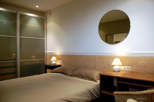 シッチェスにあるCasa Sol, Villa Incomparable, Sitges, Barcelonaのベッドルーム1室(ベッド1台、壁掛け鏡付)