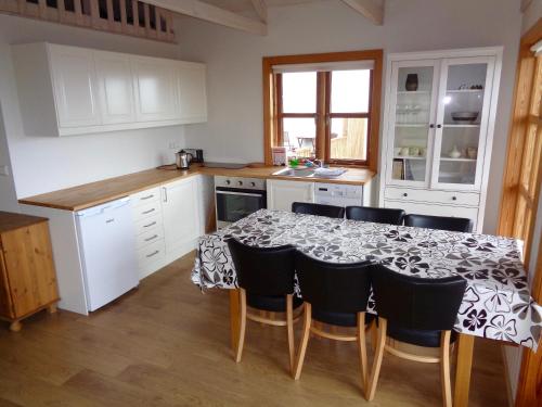 una cucina con un tavolo con sedie e mobili bianchi di Hali Country Hotel a Gerdi
