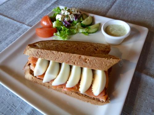 a sandwich cut in half on a white plate at Hali Country Hotel in Hali