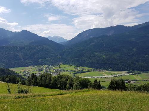 a green field with mountains in the background at Stoffenhof in Oberdrauburg