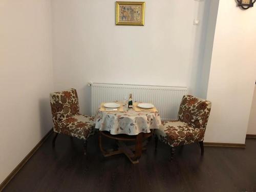 a table with two chairs and a table with plates on it at Homestay Marius in Sibiu