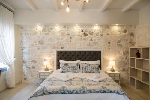 a bedroom with a large bed with two books on it at Theodore Suite in Rethymno Town