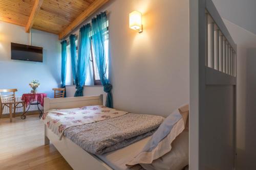 a bedroom with a bed with blue curtains at Villa Bezycer in Gowidlino